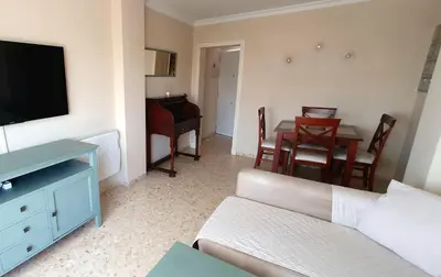 a living room with a couch and a table with a piano at Apartamento a pie de playa La Barrosa in Chiclana de la Frontera