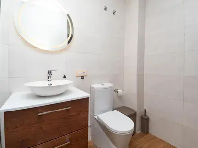 a bathroom with a sink and a toilet and a mirror at Piso San Roque in Sanlúcar de Barrameda