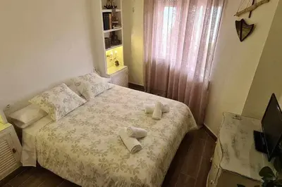 a small bedroom with a bed with towels on it at Ático Reig frente al mar in Sanlúcar de Barrameda