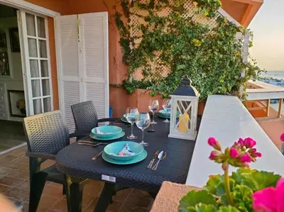 a table with plates and wine glasses on a patio at Ático Reig frente al mar in Sanlúcar de Barrameda