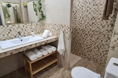 a bathroom with a sink and a toilet at Ático Reig frente al mar in Sanlúcar de Barrameda