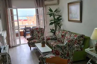a living room with a couch and a table at Ático Reig frente al mar in Sanlúcar de Barrameda
