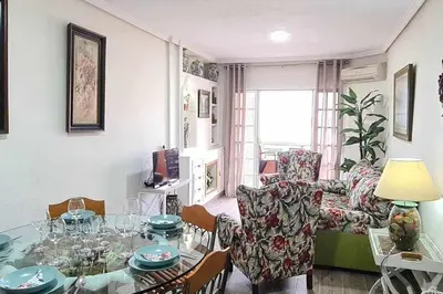 a living room with a glass table and a couch at Ático Reig frente al mar in Sanlúcar de Barrameda