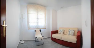 a living room with a couch and a lamp at Brasil Playa Ha Apartment in Cádiz