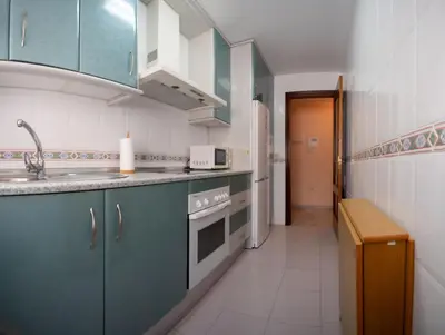a kitchen with blue cabinets and a sink at Brasil Playa Ha Apartment in Cádiz