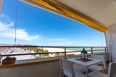 a balcony with a table and chairs and a view of the ocean at Mirador del Guadalquivir in Sanlúcar de Barrameda