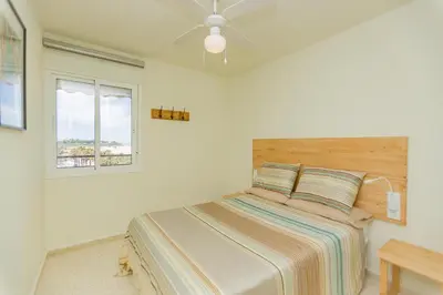 a white bedroom with a bed and a window at Mirador del Guadalquivir in Sanlúcar de Barrameda