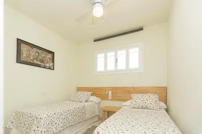 a bedroom with two beds and a window at Mirador del Guadalquivir in Sanlúcar de Barrameda