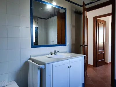 a bathroom with a white sink and a mirror at El Cortijo de Pepa in Conil de la Frontera