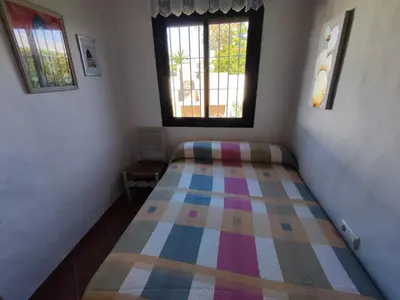 a bedroom with a bed with a colorful blanket on it at El Cortijo de Pepa in Conil de la Frontera