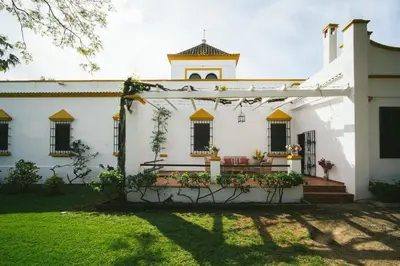 a white building with windows and a clock tower at Villa La Jara Sanlúcar in Sanlúcar de Barrameda