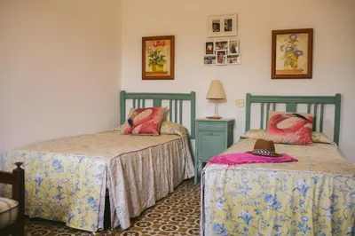 a bedroom with two beds and a table with a lamp at Villa La Jara Sanlúcar in Sanlúcar de Barrameda