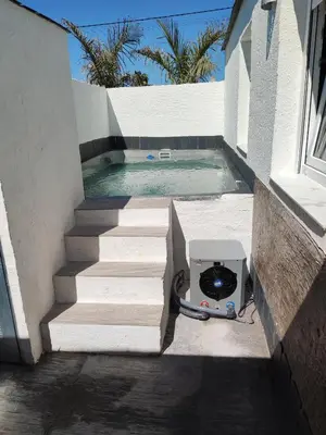 a slow cooker on the side of a house next to a swimming pool at Villa Bali con jacuzzi climatizado y piscina climatizada con jacuzzi in Chiclana de la Frontera