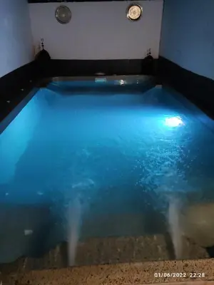 a swimming pool with blue water in a room at Villa Bali con jacuzzi climatizado y piscina climatizada con jacuzzi in Chiclana de la Frontera