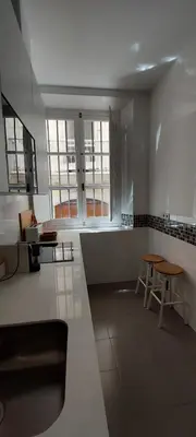 a large kitchen with two tables and two windows at el 2 de Flamenco BajoB in Cádiz