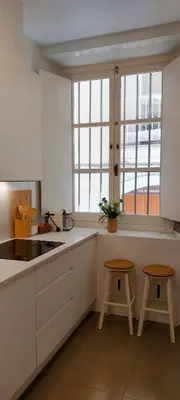 a kitchen with white counters and two stools in it at el 2 de Flamenco BajoB in Cádiz