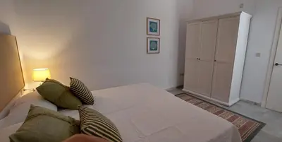 a bedroom with a large bed and a cabinet at el 2 de Flamenco BajoB in Cádiz