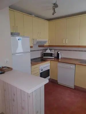 a kitchen with yellow cabinets and white appliances at Luceros in Rota