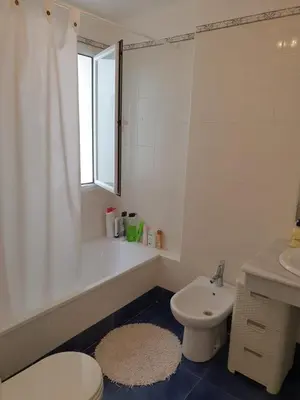 a bathroom with a tub and a toilet and a sink at Luceros in Rota
