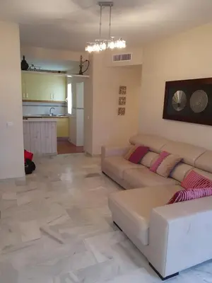 a living room with two couches and a kitchen at Luceros in Rota