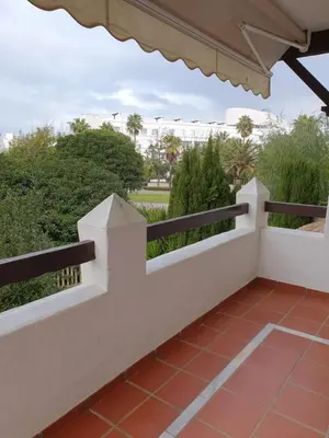 a white railing on a balcony with a view of a park at Luceros in Rota
