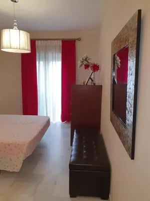 a bedroom with a bed and a bench in a room at Luceros in Rota