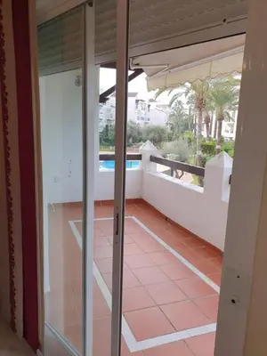 a glass door of a balcony with a view of a pool at Luceros in Rota