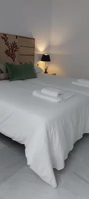 a large white bed in a room with a lamp at el 2 de Flamenco 1ºB in Cádiz
