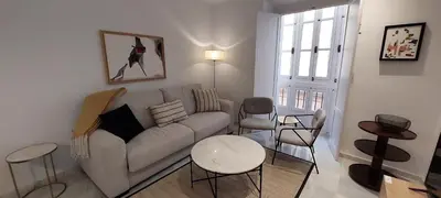 a living room with a couch and a table and chairs at el 2 de Flamenco 1ºB in Cádiz