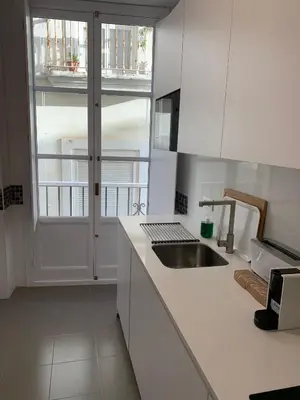 a white kitchen with a sink and a window at el 2 de Flamenco 2ºB in Cádiz
