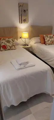 a bedroom with two beds and a lamp on a table at el 2 de Flamenco 1ºA in Cádiz
