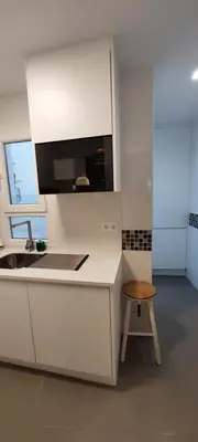 a white kitchen with a sink and a stool at el 2 de Flamenco 1ºA in Cádiz