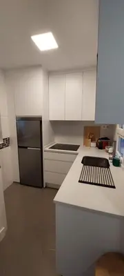 a kitchen with white cabinets and a black refrigerator at el 2 de Flamenco 1ºA in Cádiz