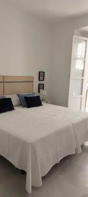 a white bedroom with a large white bed at el 2 de Flamenco 1ºA in Cádiz
