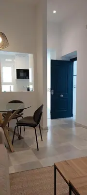 a living room with a table and a blue door at el 2 de Flamenco 2ºA in Cádiz