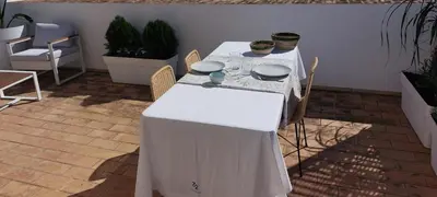 a table with a white table cloth on it at el 2 de Flamenco Ático 3ºB in Cádiz