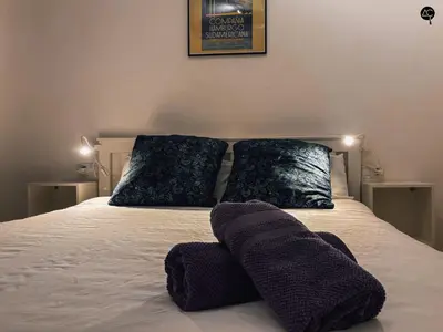 a bed with two pillows and purple towels on it at Dolce Vita en la Caleta Grupo AC Gestion in Cádiz