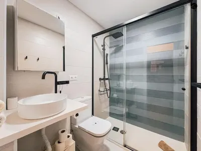 a bathroom with a sink and a glass shower at Dolce Vita en la Caleta Grupo AC Gestion in Cádiz