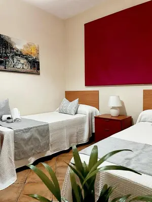 a room with two beds and a red painting on the wall at Chalet Hercules la barrosa in Chiclana de la Frontera