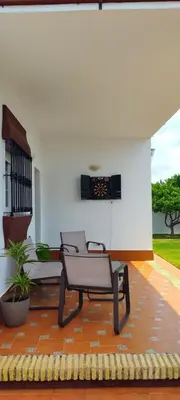 a patio with a bench and a white building at Chalet Hercules la barrosa in Chiclana de la Frontera