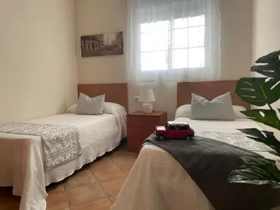 a bedroom with two beds with a toy car on the bed at Chalet Hercules la barrosa in Chiclana de la Frontera