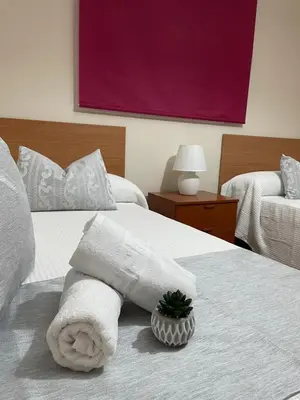 a hotel room with a towel on a bed at Chalet Hercules la barrosa in Chiclana de la Frontera