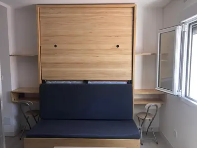a bed in a room with two chairs and a cabinet at Torredelfino in Jerez de la Frontera