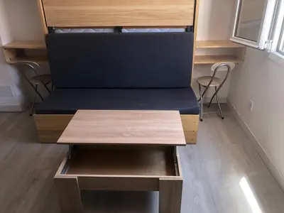 a bed in a tiny house with two stools at Torredelfino in Jerez de la Frontera
