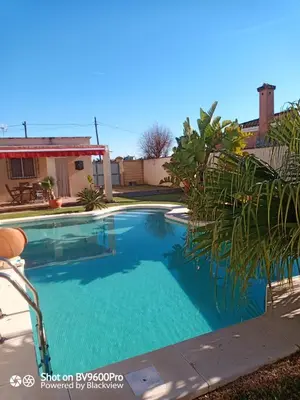 a swimming pool with blue water in a yard at El Vaivén in El Puerto de Santa María