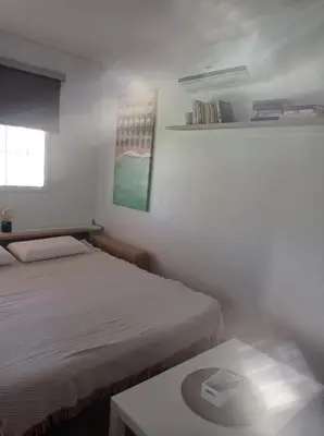 a white room with two beds and a table at El Vaivén in El Puerto de Santa María
