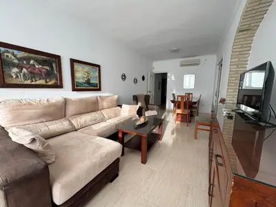 a living room with a couch and a tv at Aires de Regla, Apartamentos Living Sur in Chipiona