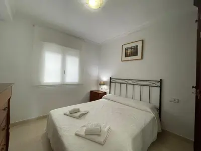 a bedroom with a bed with two towels on it at Aires de Regla, Apartamentos Living Sur in Chipiona