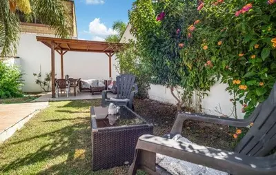 a wooden bench sitting in a yard with a tree at Villa Lolera in Chiclana de la Frontera