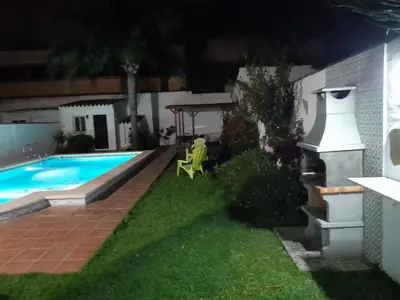 a backyard at night with a swimming pool at Villa Lolera in Chiclana de la Frontera